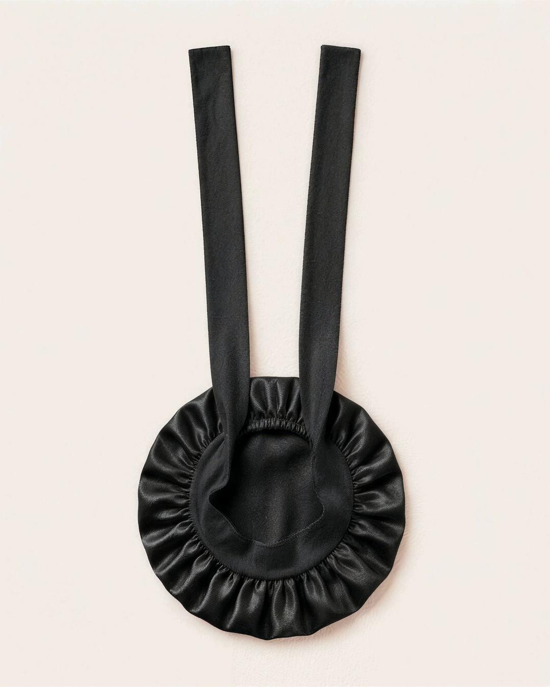Black silk bonnet laid flat with its ties extended