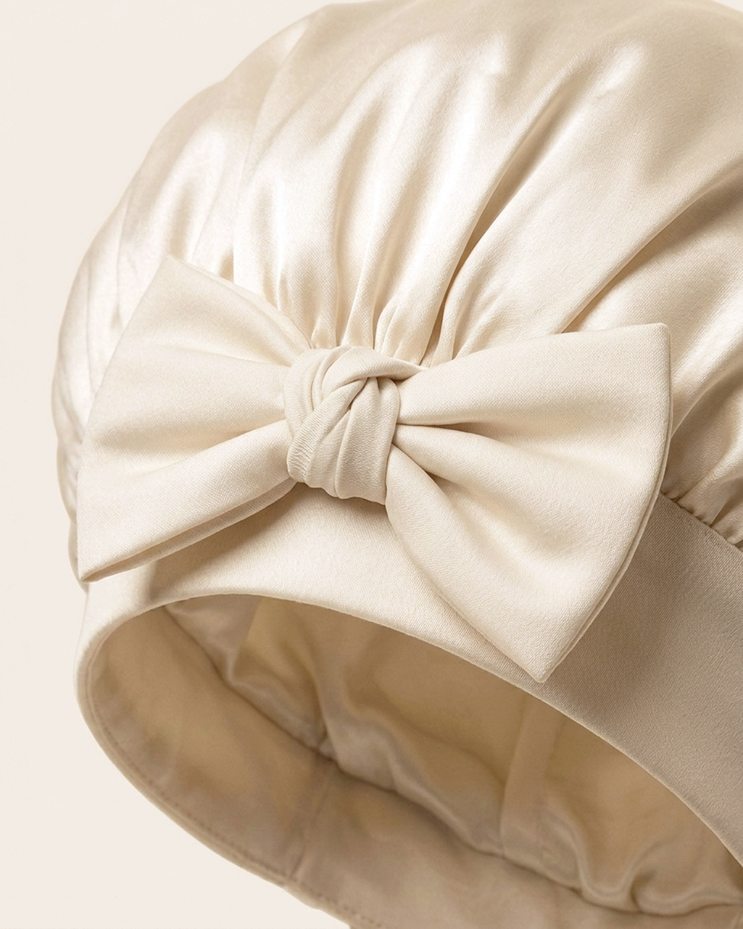 Close-up of the bow on the soft band of the ivory silk bonnet