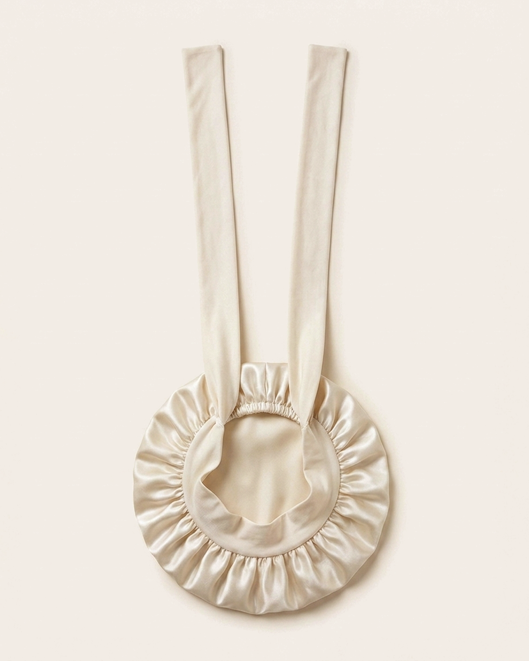 Ivory silk bonnet laid flat with its ties extended