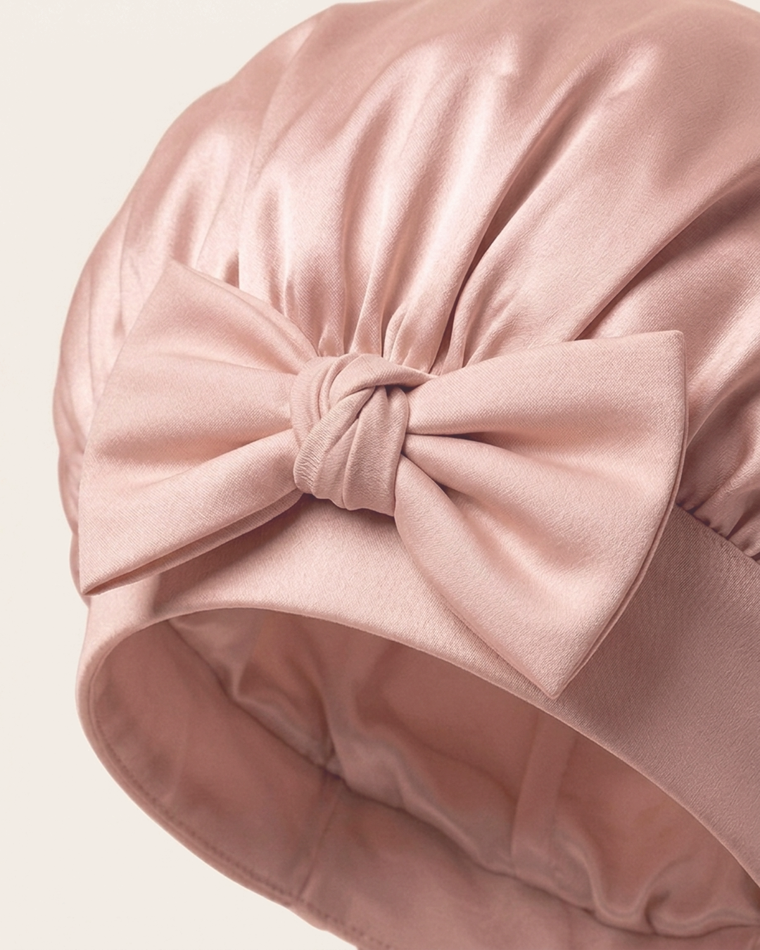 Close-up of the bow on the soft band of the pink silk bonnet