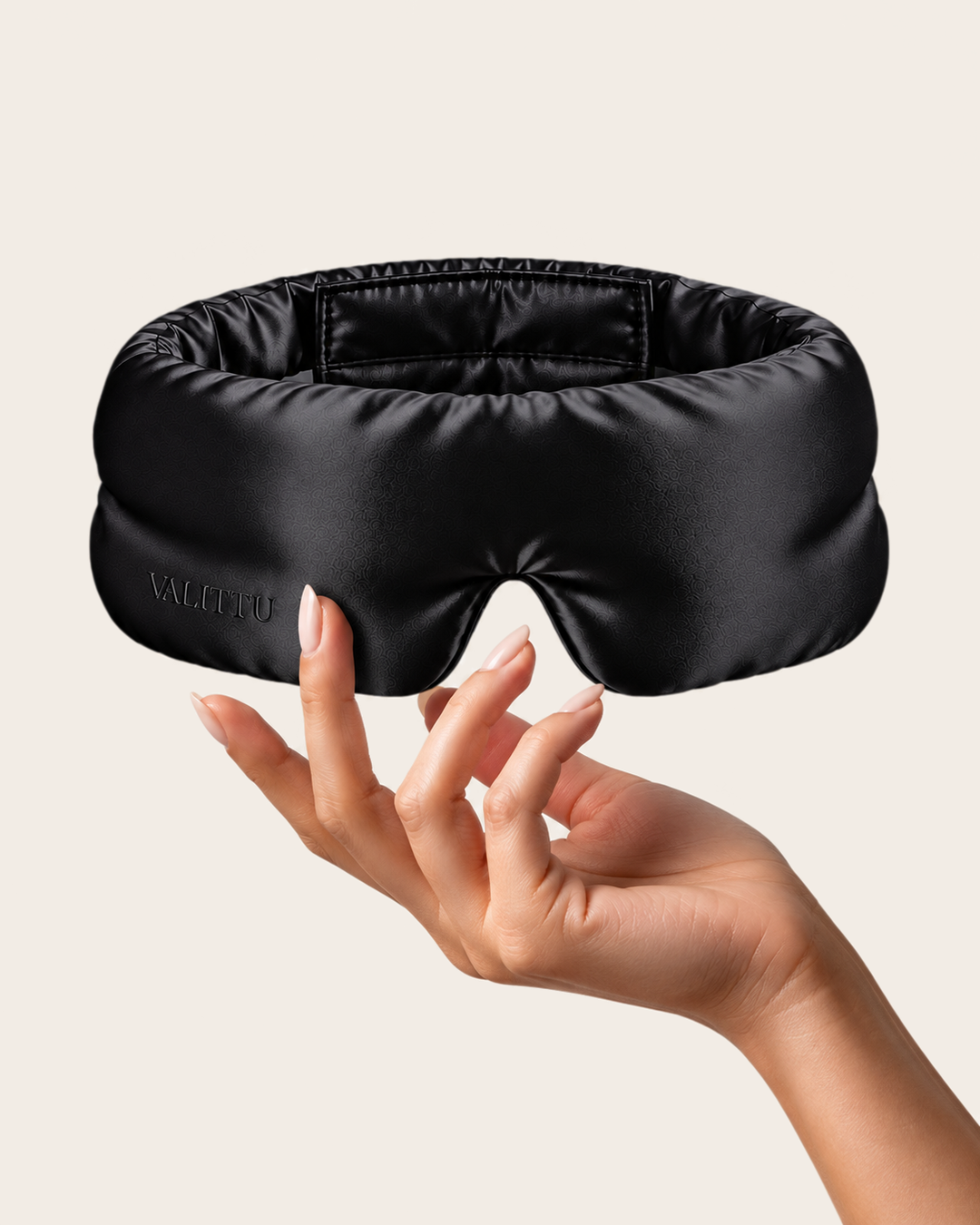 Hand holding the black silk sleep mask