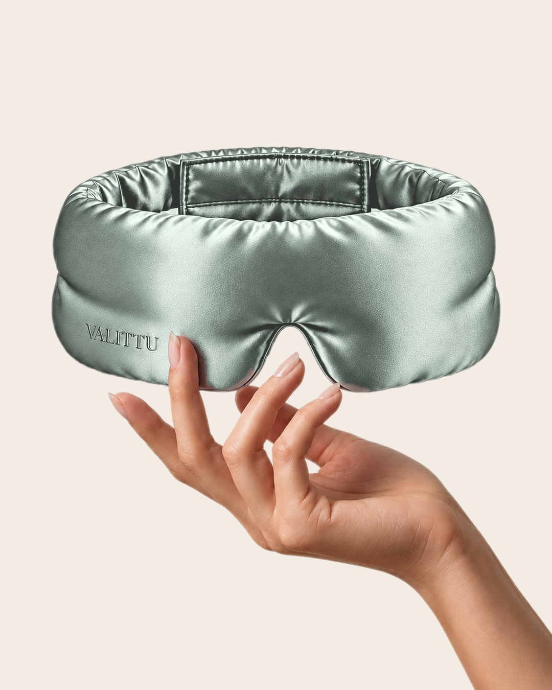 Hand holding the green mist silk sleep mask