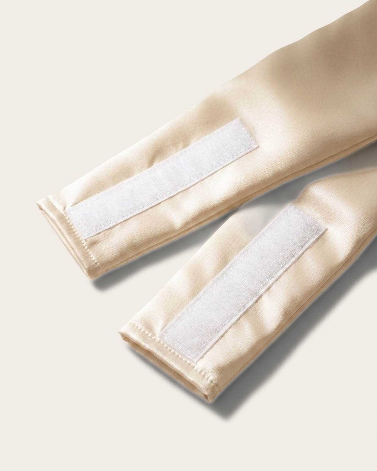 Close-up of the wide silk strap and soft velcro closure on the ivory sleep mask