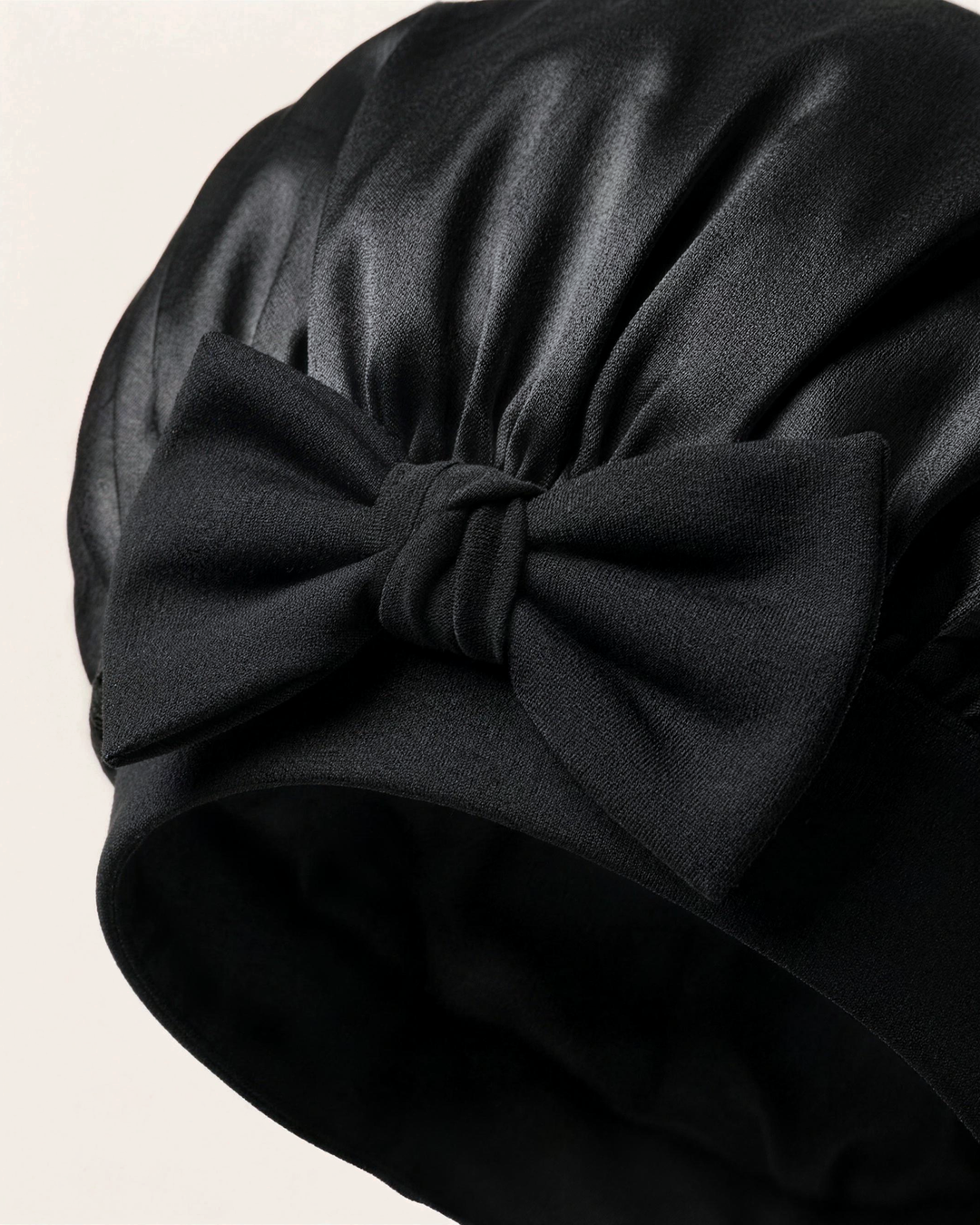 Close-up of the bow on the soft band of the black silk bonnet