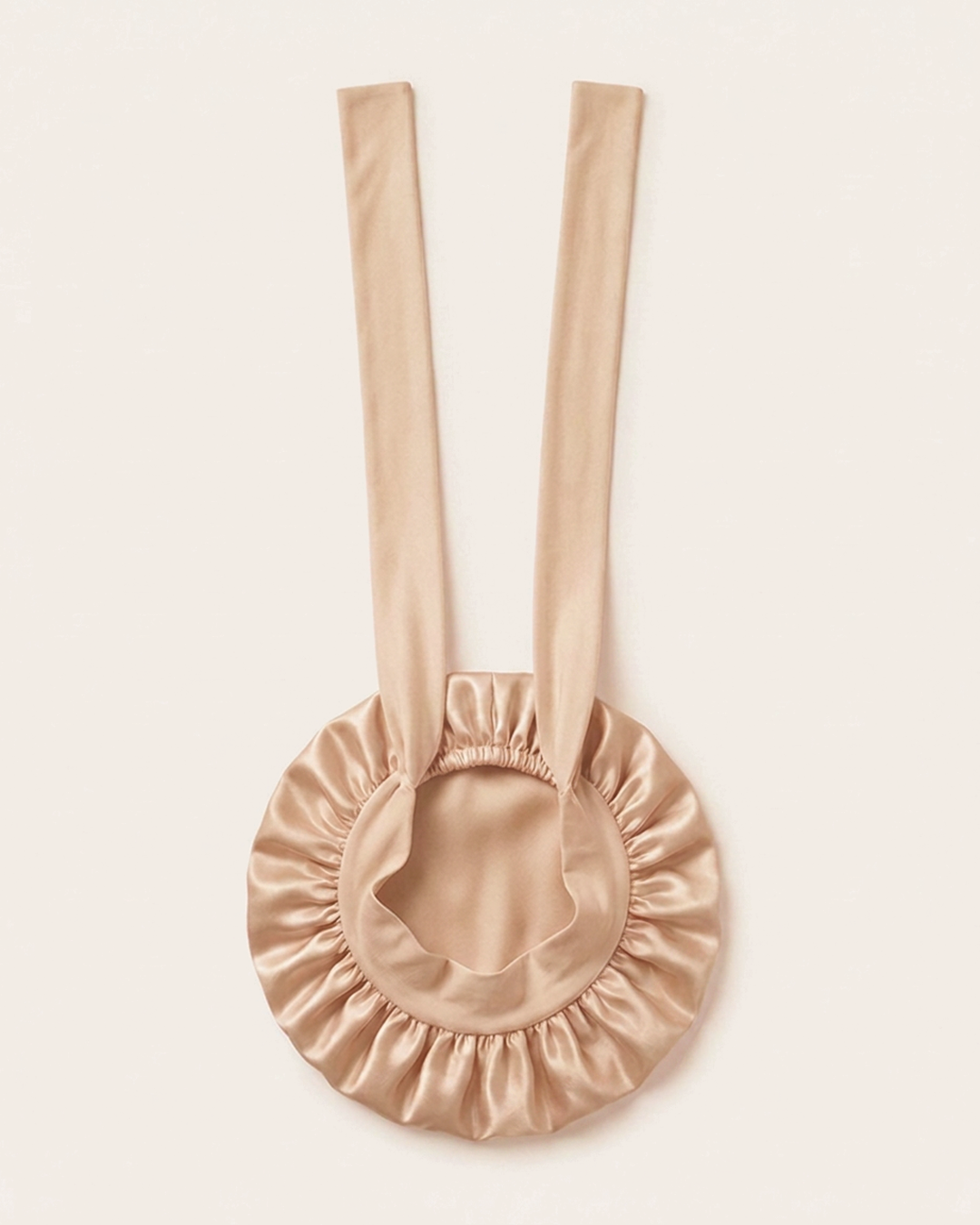 Rose Gold silk bonnet laid flat with its ties extended