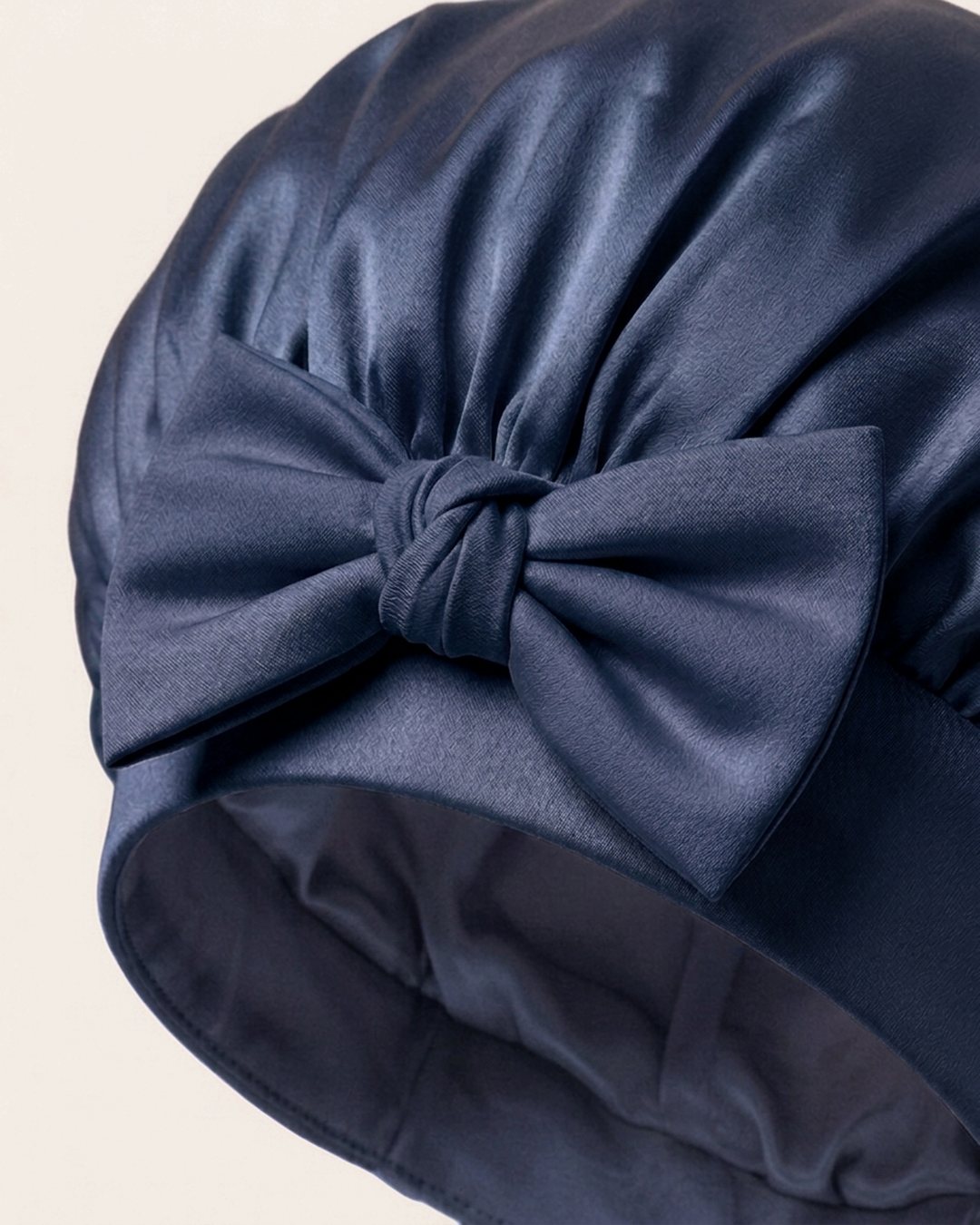 Close-up of the bow on the soft band of the navy silk bonnet