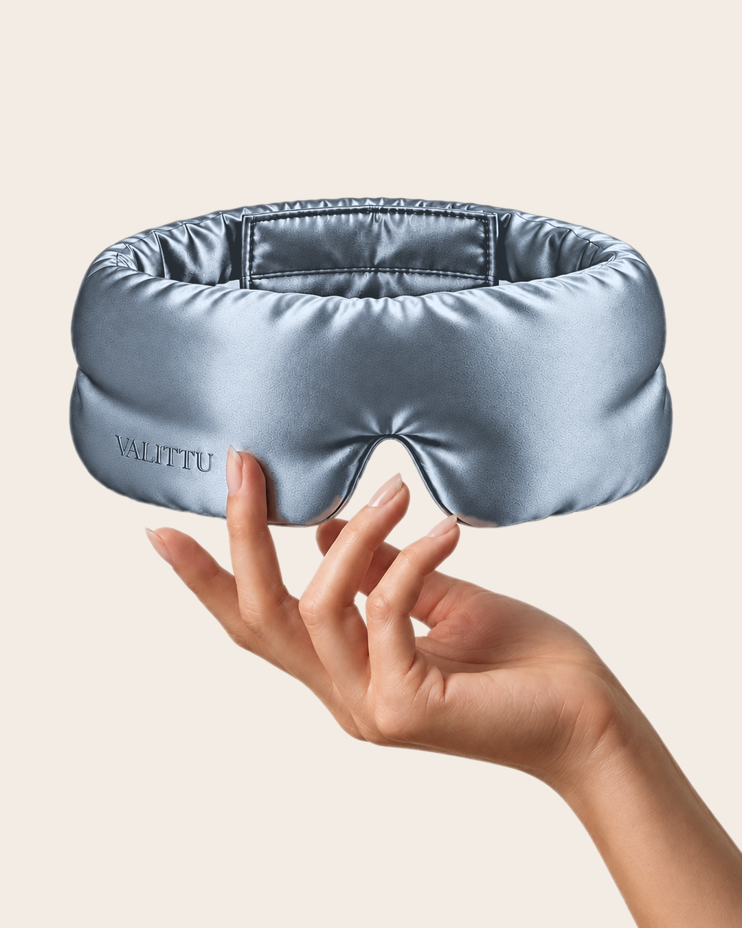 Hand holding the blue mist silk sleep mask